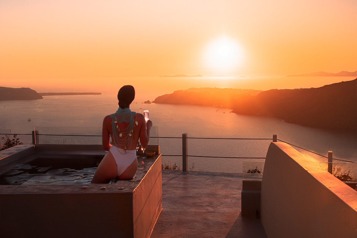 Anna Myrha in Gizis Hotel at Imerovigli, watching the Santorini Sunset. The Ultimate Santorini Photo Guide blog post